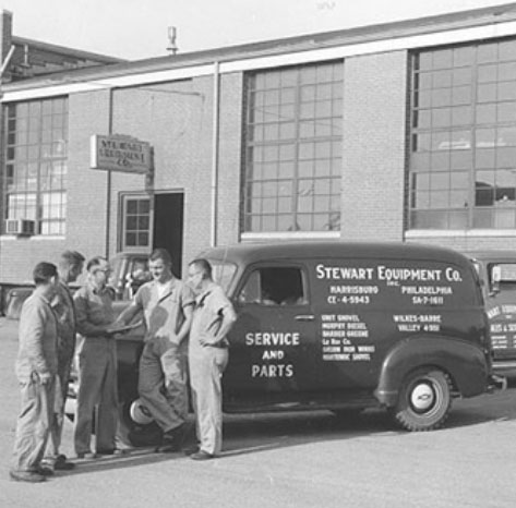 1940s employees gathered around a Stewart-Amos Equipment Vehicle